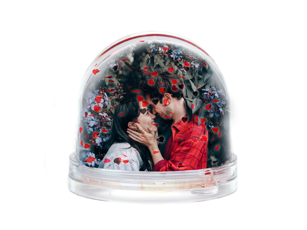 Glitzerkugel mit roten Herzen und Herzflocken zeigt ein Paar, das sich liebevoll ins Gesicht fasst und innig anschaut.