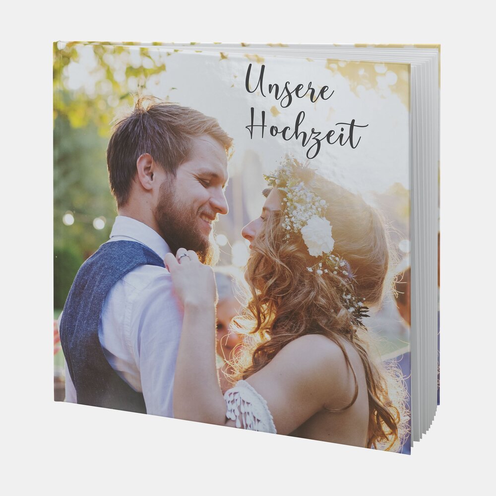 Ein verliebtes Brautpaar tanzt auf dem Cover eines quadratischen Fotobuchs mit dem Titel „Unsere Hochzeit“.