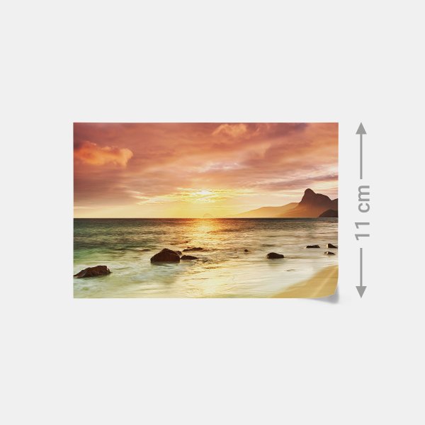 Ein stimmungsvoller Sonnenuntergang am Strand mit Felsen als Fotoabzug auf hochwertigem Fotopapier zum Bestellen.