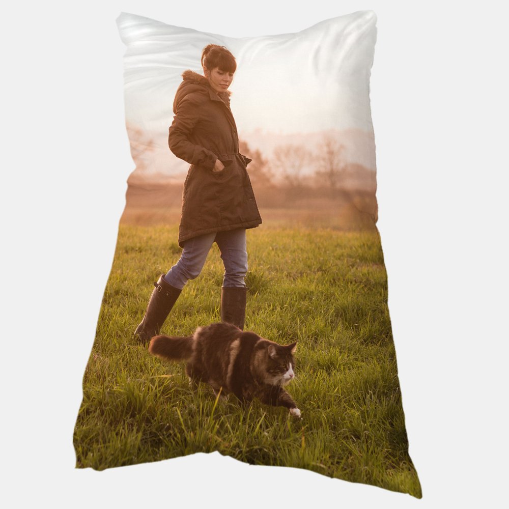 Abgebildet ist ein  Fotokissen mit einer Frau, die bei Sonnenuntergang mit ihrer Katze über eine Wiese spaziert.