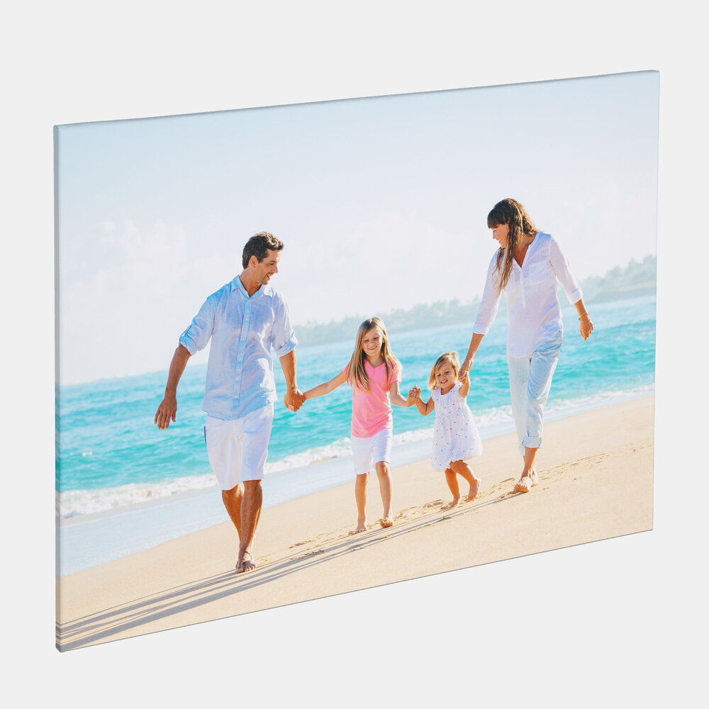 Auf der Leinwand ist eine Familie am Strand zu sehen, die barfuß nebeneinander läuft und sich an den Händen hält.