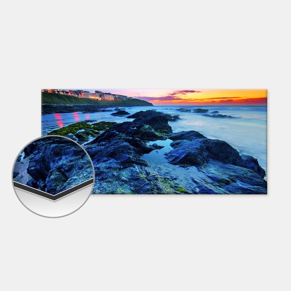 Die Alu-Dibond-Platte zeigt eine felsige Küste bei Sonnenuntergang, darunter ein Detailausschnitt der Kantenstruktur.