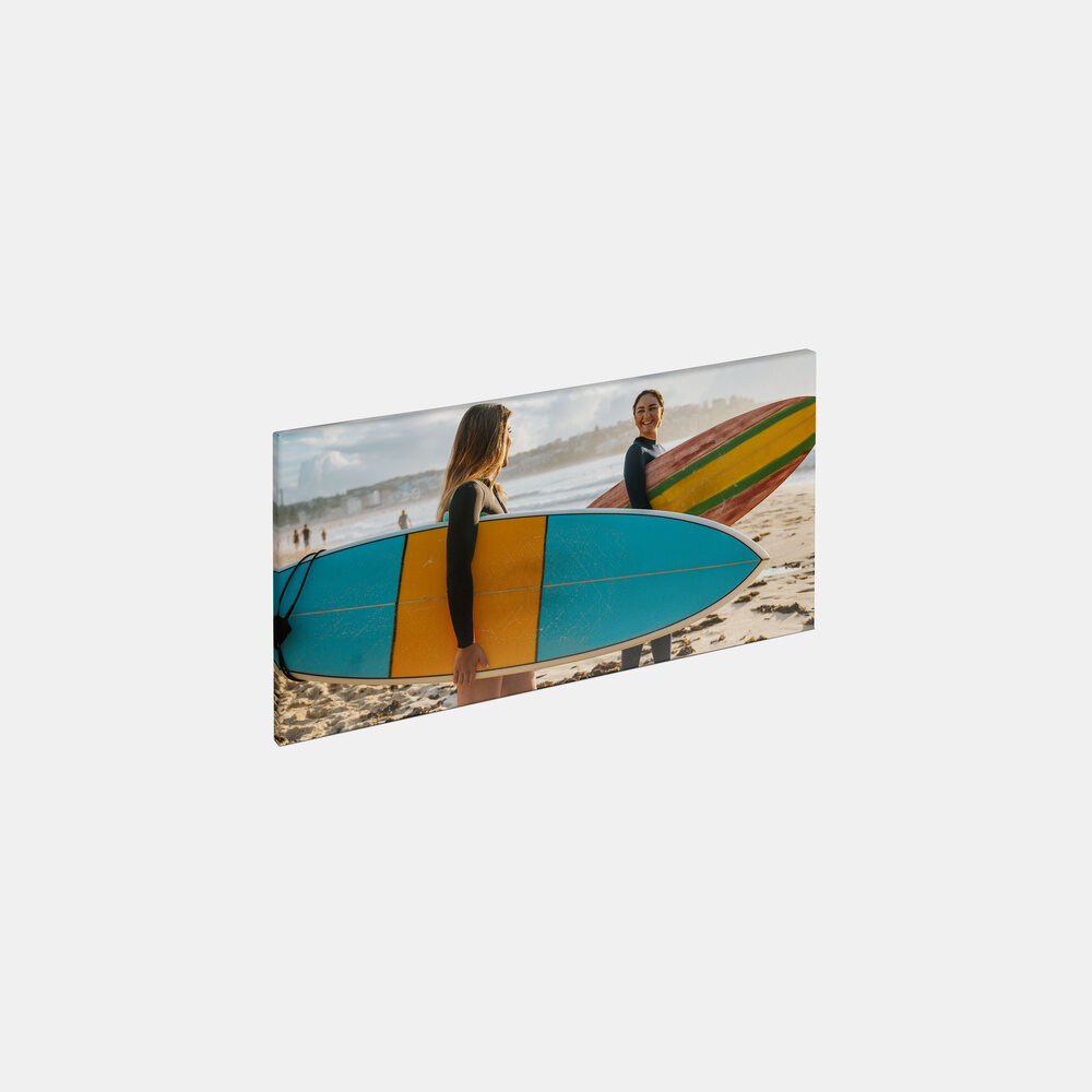 Die Leinwand im Querformat 20x40 cm zeigt zwei Frauen mit Surfbrettern am Strand bei sonnigem Wetter.